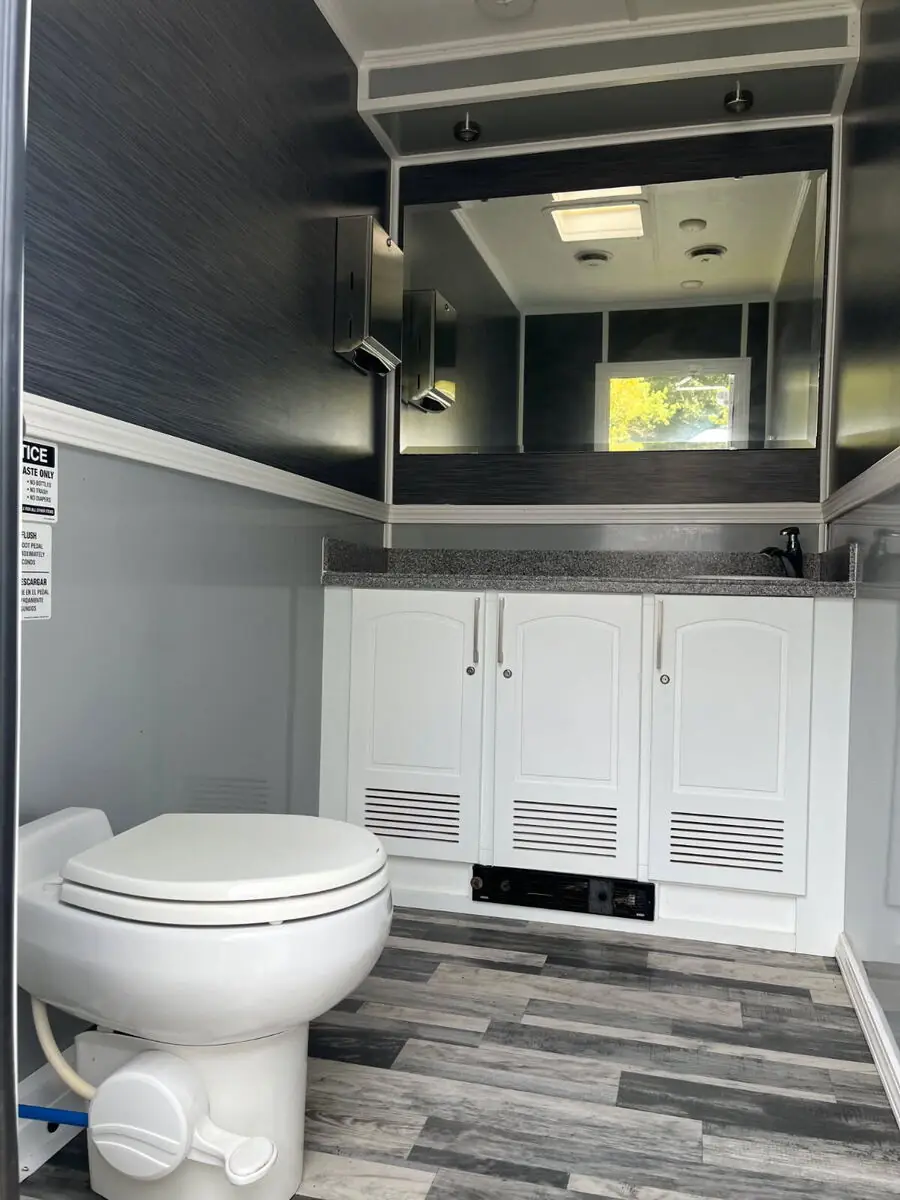 Restroom trailer vanity with sink, white cabinets and full mirror